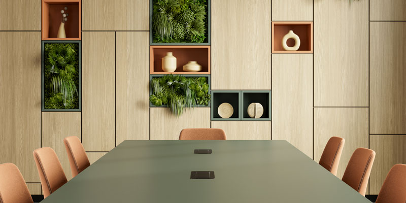 An office with blush and olive coloured furniture.