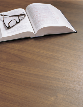 Plan de travail en grain de bois avec livre ouvert et lunettes