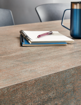 A countertop with notebooks and a pen