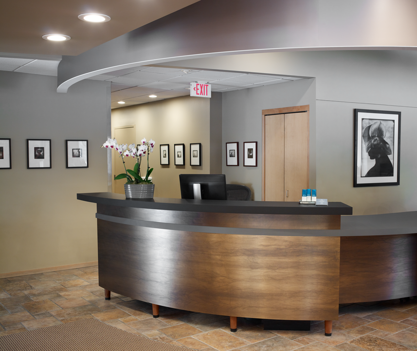 A front welcome desk with a metallic front and pictures all around.