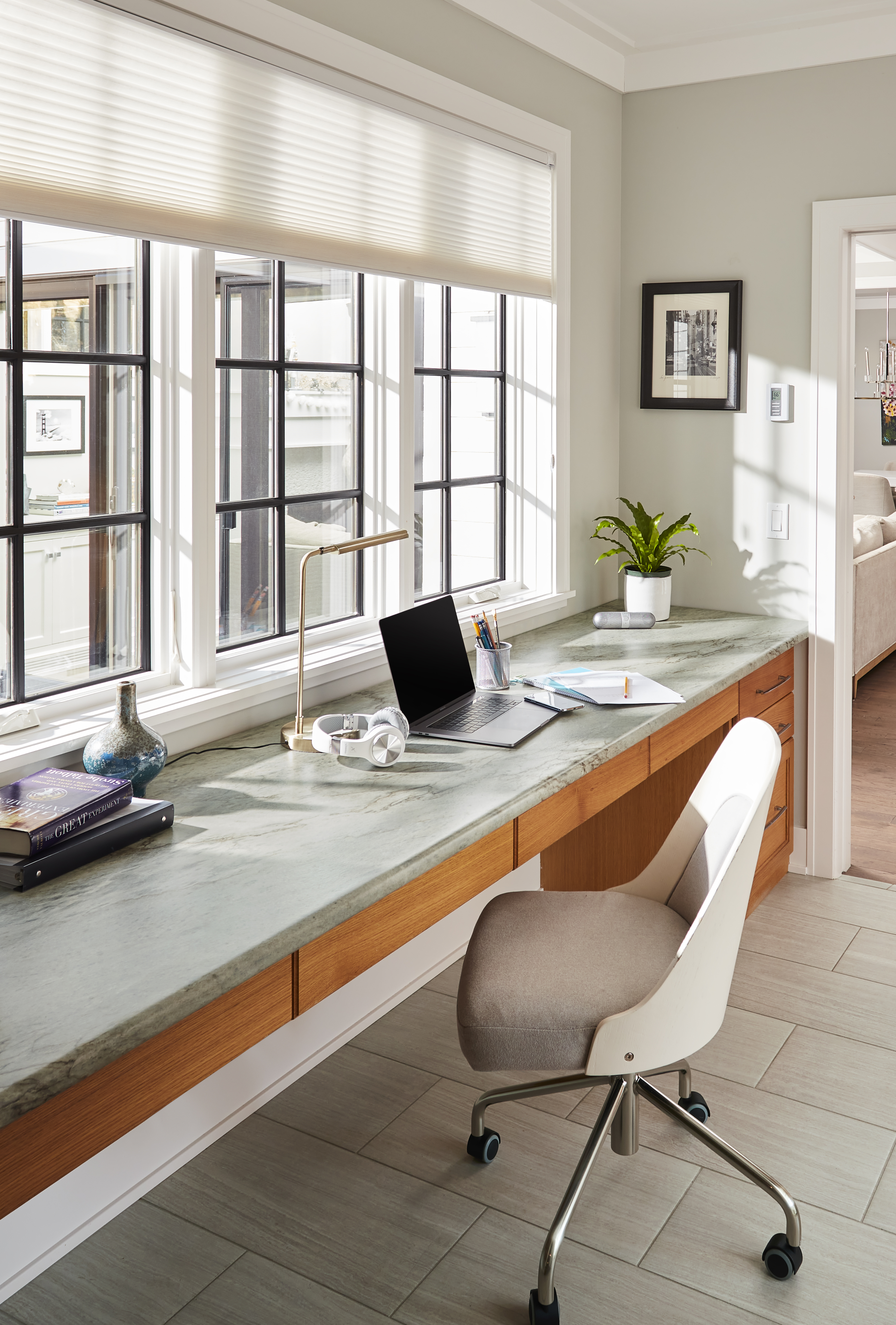 A home office desk with a woodgrain base and a cool, mint stone-look top.