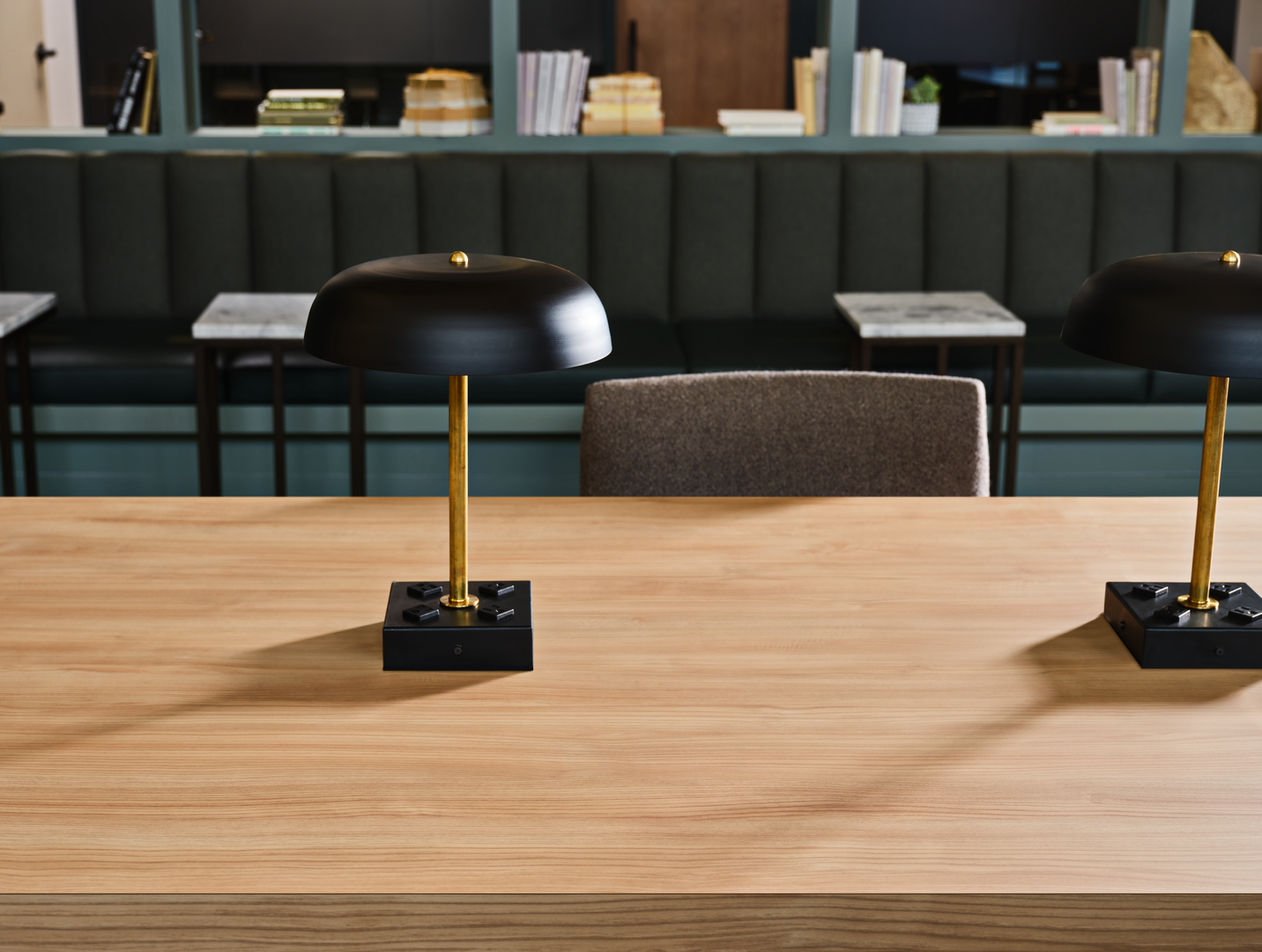 Une table en grain de bois avec une lampe de table noire et des bancs